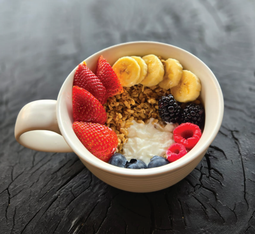 Bowl de yogurt con granola, fresas, plátano y frutos rojos