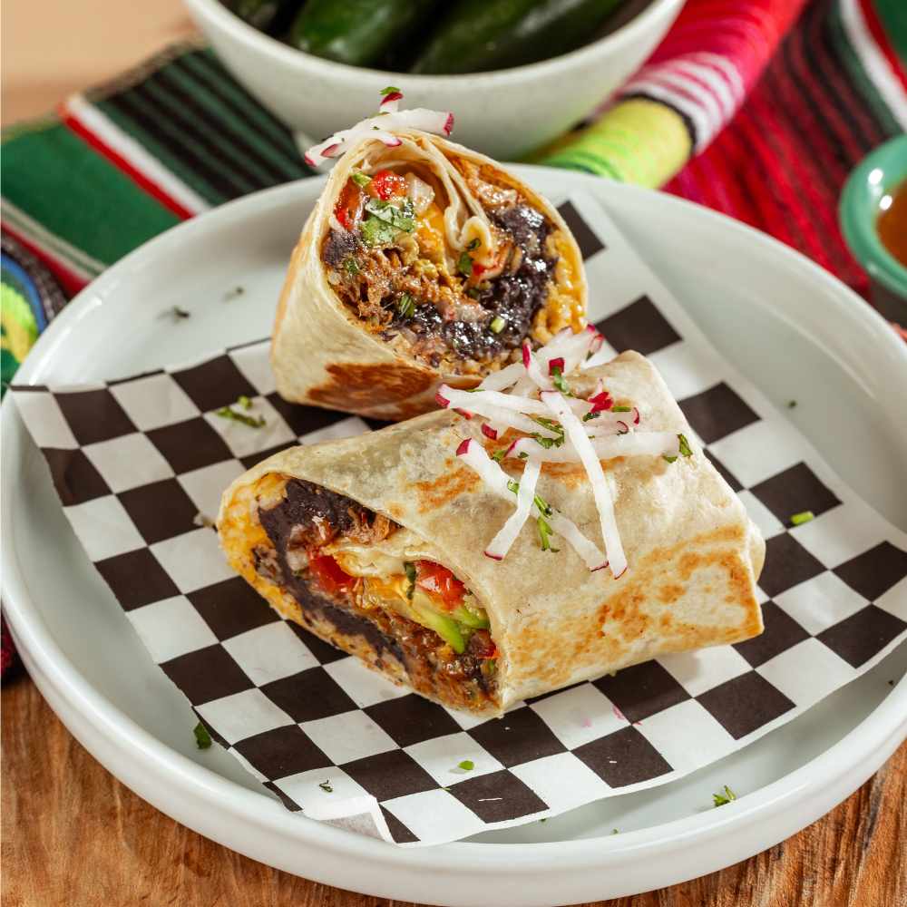 Burrito estilo Baja cortado a la mitad sobre papel a cuadros