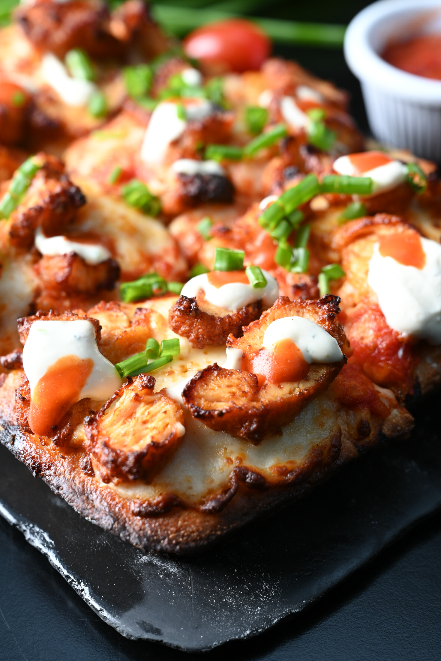 Pizza Buffalo estilo Detroit de Botanica Pizza, cuadrada, con pollo, salsa buffalo, ranch y borde de queso dorado